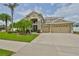Inviting two-story home with a three-car garage, lush landscaping, and a grand entryway at 13728 Artesa Bell Dr, Riverview, FL 33579