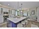 Bright kitchen with a large island, white cabinets, pendant lighting, and stainless appliances at 13728 Artesa Bell Dr, Riverview, FL 33579
