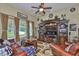 Cozy living room with a ceiling fan, large entertainment center, and plush leather seating at 13728 Artesa Bell Dr, Riverview, FL 33579
