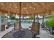 Outdoor patio featuring a seating area with umbrella, lounge chairs and lush landscaping at 13728 Artesa Bell Dr, Riverview, FL 33579