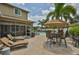 Spacious backyard patio with an umbrella-covered dining table and lounge chairs near a pool at 13728 Artesa Bell Dr, Riverview, FL 33579