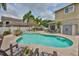 This backyard features a pool surrounded by palm trees, lounge chairs, and outdoor furniture at 13728 Artesa Bell Dr, Riverview, FL 33579