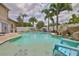 The pool has a rock waterfall feature and a shallow beach area with a lounge chair at 13728 Artesa Bell Dr, Riverview, FL 33579