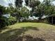 Expansive backyard featuring lush lawn, mature trees, and privacy fence, ideal for outdoor activities at 1548 Foxboro Dr, Palm Harbor, FL 34683