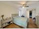 Bright bedroom with wood floors, a ceiling fan, and an attached closet at 1548 Foxboro Dr, Palm Harbor, FL 34683