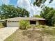 Charming home featuring a well-manicured front yard and a two-car garage with a paved driveway at 1548 Foxboro Dr, Palm Harbor, FL 34683