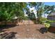 Spacious backyard with lush trees, a wood fence, and a small storage shed at 15623 Morgan St, Clearwater, FL 33760
