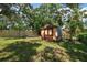 Backyard featuring a small shed in a yard surrounded by trees and a wood fence at 15623 Morgan St, Clearwater, FL 33760