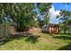 Backyard featuring a wood fence and a shed in a yard covered with trees at 15623 Morgan St, Clearwater, FL 33760