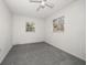 This bedroom features white walls, grey carpeting, and a bright ceiling fan at 15623 Morgan St, Clearwater, FL 33760