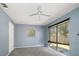 This bedroom features blue walls, a ceiling fan, and a sliding glass door leading to the outside at 15623 Morgan St, Clearwater, FL 33760