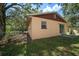 Side view of a home with a small window, sliding glass door, and a yard at 15623 Morgan St, Clearwater, FL 33760