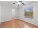 Clean bedroom featuring hardwood floors, ceiling fan and a large window at 15636 Morning Dr, Lutz, FL 33559