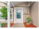Inviting front entrance with a storm door, complemented by lush landscaping and a pop of color from the potted plant at 15636 Morning Dr, Lutz, FL 33559