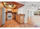 Bright kitchen featuring stainless steel appliances, wooden cabinetry, and tile flooring at 15636 Morning Dr, Lutz, FL 33559