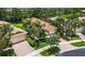 Aerial view showcases home with lush landscaping, and brick driveway at 15744 Crystal Waters Dr, Wimauma, FL 33598