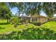 Beautiful backyard featuring lush green grass and tropical landscaping at 15744 Crystal Waters Dr, Wimauma, FL 33598