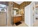 A full secondary bath includes decorative wallpaper, wood vanity, and frameless glass-enclosed shower at 15744 Crystal Waters Dr, Wimauma, FL 33598