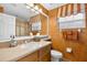 Well-lit bathroom with a single sink vanity, mirror, and orange and white wallpaper at 15744 Crystal Waters Dr, Wimauma, FL 33598