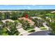 Beautiful single-story home with a red tile roof, lush landscaping, and a brick paver driveway at 15744 Crystal Waters Dr, Wimauma, FL 33598