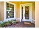 Inviting front entrance with a decorative wreath, potted plants, and a tiled porch at 15744 Crystal Waters Dr, Wimauma, FL 33598