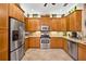 Modern kitchen with stainless steel appliances, wood cabinets, tiled backsplash, and ample counter space at 15744 Crystal Waters Dr, Wimauma, FL 33598
