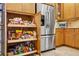 Kitchen storage with pull out shelves and stainless steel refrigerator at 15744 Crystal Waters Dr, Wimauma, FL 33598