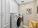 Bright laundry room with white cabinetry over washer and dryer at 15744 Crystal Waters Dr, Wimauma, FL 33598