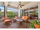 Relaxing screened patio with comfortable seating, ceiling fans, and beautiful outdoor views at 15744 Crystal Waters Dr, Wimauma, FL 33598