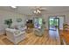 Bright living room featuring hardwood floors, neutral paint, and sliding glass doors to the patio at 2417 Locksley St # 229, Sun City Center, FL 33573
