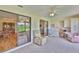 Bright sunroom featuring tile floors, built-in cabinets, comfortable seating and access to the lanai at 2417 Locksley St # 229, Sun City Center, FL 33573