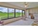Sunroom with a beautiful golf course view through expansive windows and built-in storage at 2417 Locksley St # 229, Sun City Center, FL 33573