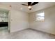 Minimalist bedroom with gray floors, bright walls, and a view into the open kitchen at 3025 Palamore Dr, Holiday, FL 34691