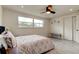 Well-lit bedroom features stylish gray flooring, ceiling fan, and a comfortable bench at 3025 Palamore Dr, Holiday, FL 34691