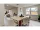 Bright dining area with tile floors, modern table, and a view into the adjacent living room at 3025 Palamore Dr, Holiday, FL 34691