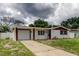 Charming home showcasing a white exterior, brown trim, and a spacious driveway at 3025 Palamore Dr, Holiday, FL 34691