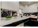 This modern kitchen features white cabinetry, black marble backsplash, quartz counters and stainless steel appliances at 3025 Palamore Dr, Holiday, FL 34691