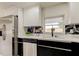 Updated kitchen featuring stainless steel appliances, black and white cabinets, quartz countertops, and black marble backsplash at 3025 Palamore Dr, Holiday, FL 34691