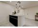 Kitchen island with quartz countertop, black cabinets, pendant lighting, and access to the dining area at 3025 Palamore Dr, Holiday, FL 34691