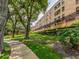 Exterior showcases multi-story building with balconies and manicured landscaping, complemented by a sidewalk and mature trees at 3078 Eastland Blvd # 205, Clearwater, FL 33761
