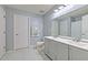 Bright bathroom featuring double sinks, large mirror, and a shower with white marble tile flooring at 3110 Royal Tuscan Ln, Valrico, FL 33594