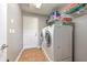 The laundry room features a washer, dryer, and storage shelving at 3110 Royal Tuscan Ln, Valrico, FL 33594