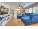 The open-concept living room features a cozy blue sectional, a ceiling fan, and plenty of natural light at 3110 Royal Tuscan Ln, Valrico, FL 33594
