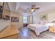 The Primary bedroom features wood floors, modern decor, a ceiling fan, and a decorative painting at 3110 Royal Tuscan Ln, Valrico, FL 33594