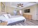 Comfortable main bedroom featuring tray ceiling, ceiling fan, TV, and ensuite bathroom access at 3110 Royal Tuscan Ln, Valrico, FL 33594