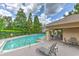 Relaxing pool with a lounge chair on the paved deck and an outdoor kitchen/eating area at 3110 Royal Tuscan Ln, Valrico, FL 33594