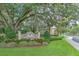 A stone sign reading Wedgewood, manicured garden area and large oak trees at the entrance at 3110 Royal Tuscan Ln, Valrico, FL 33594