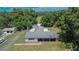 An aerial view of single story home with gray roof and covered front porch surrounded by lush greenery in a rural setting at 3212 Cork Rd, Plant City, FL 33565