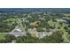 Expansive aerial view of a charming property nestled among lush greenery and mature trees in a serene neighborhood at 3212 Cork Rd, Plant City, FL 33565