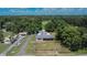 An aerial shot shows a single-Gathering home and outbuildings in lush, green surroundings, and long driveway at 3212 Cork Rd, Plant City, FL 33565